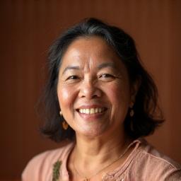 Portrait of Eliza Baltazar, a skilled potter, smiling with tools.